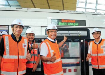 Saifuddin Nasution Ismail menunjukkan tren RTS ketika mengadakan lawatan kerja bagi tinjauan pengoperasian di RTS Link dan ICQS Stesen Bukit Chagar, di Johor Bahru. UTUSAN/RAJA JAAFAR ALI