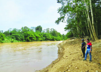 MOHD. Azmawi Fikri Abdul Ghani (kanan) melihat keadaan tebing sungai Neggeri Gua Musang, Kelantan yang terhakis akibat aktiviti pam pasir.