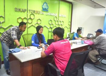 AHMAD Firdaus Hashim (kiri) memantau keadaan di kaunter Perkeso di Kangar, Perlis, semalam. - UTUSAN/ASYRAF MUHAMMAD