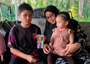 NORAZIAN Mohd. Joned bersama dua anaknya ketika ditemui di Kampung Sungai Itik, Gopeng, Perak setahun selepas tragedi.