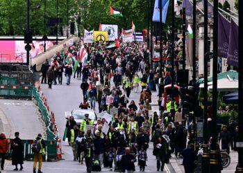 Penunjuk perasaan yang membawa bendera Palestin di London kelmarin. - AFP.