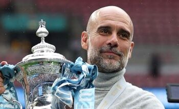 Pep Guardiola memegang Piala FA selepas pasukan bimbingannya menewaskan Chelsea 1-0 pada perlawanan akhir di Stadium Wembley, London, kelmarin. - AFP   