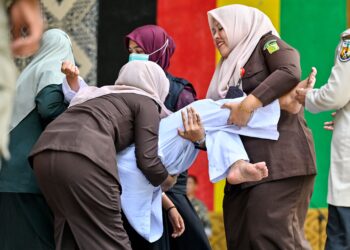 SEORANG wanita pengsan selepas disebat di Banda Aceh hari ini. - AFP