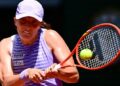Iga Swiatek membalas bola pukulan lawannya, Emerson Jones dalam tenis Terbuka Perancis di Roland Garros, Paris. - AFP
