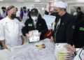 MUSTAKIM Mohamad (tengah) menunjukkan pek sajian makanan yang direka khas ketika meninjau operasi dapur haji 2026/1447H di Mekah, semalam.