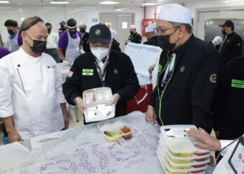 MUSTAKIM Mohamad (tengah) menunjukkan pek sajian makanan yang direka khas ketika meninjau operasi dapur haji 2026/1447H di Mekah, semalam.