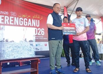 MUHAMMAD Asyraf Abu Bakar (kanan) memenangi hadiah utama cabutan bertuah RM100,000 yang disampaikan oleh Ahmad Samsuri Mokhtar sempena Terengganu Marathon 2026 di Kompleks Sukan Negeri Terengganu, Kuala Nerus, Terengganu. - MINGGUAN/ERMA YUSNIDA JUSOH