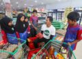 MAT Saidi Yusof (tengah) bersama sebahagian murid SK Bukit Jejulong, Marang, Terengganu membeli barangan asas keperluan rumah daripada duit hasil sumbangan orang ramai di sebuah pasar raya. – UTUSAN/PUQTRA HAIRRY