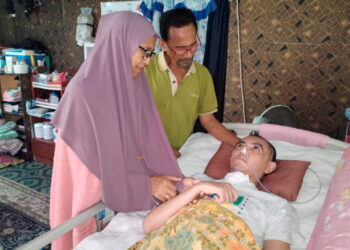 SAMSUDIN Sulaiman dan Rosnani Deraman bersama Mohamad
Fadil yang kini koma di Kampung Seri Kenangan, Setiu, Terengganu.