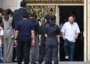 THAKSIN (kanan) keluar dari Penjara Pusat Klong Prem, Bangkok hari ini. - AFP