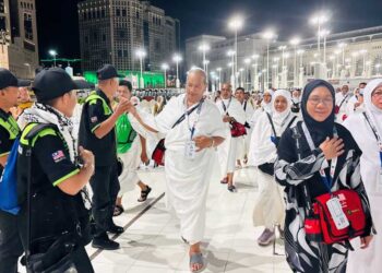 PASUKAN Peronda Haji atau dikenali Semut Hitam membantu jemaah haji menuju ke Masjidil Haram untuk menunaikan umrah. - UTUSAN/JUANI MUNIR ABU BAKAR