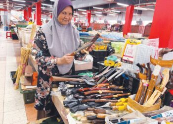 FARIDAH Mohd. Nor menunjukkan pisau lapah dijual di Pasar Siti Khadijah, Kota Bharu, Kelantan. – UTUSAN/ ROSLIZA MOHAMED
