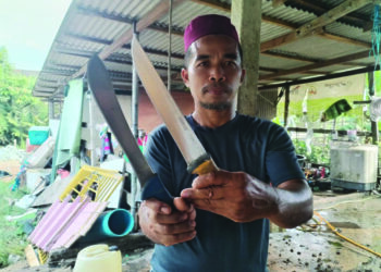 ASMADI Abdullah menunjukkan dua bilah pisau yang sering digunakan setiap kali sambutan Hari Raya Aidiladha untuk menyembelih haiwan korban ketika ditemui di Kampung Pak Kancil Dalam, Setiu, Terengganu. – MINGGUAN/WAN ZURATIKAH IFFAH WAN ZULKIFLI
