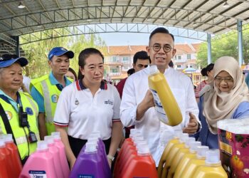 STEVEN Sim Chee Keong (dua dari kanan) menunjukkan antara barangan yang dijual pada harga subsidi sempena program JMKU di Dewan Terbuka Taman Tanjung Aman, Butterworth, Pulau Pinang.