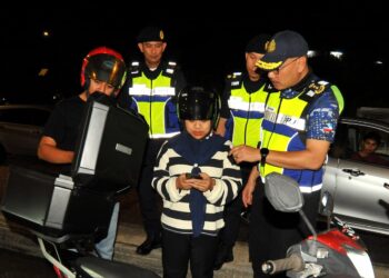 PENGARAH JPJ Johor Zulkarnain Yasin (kanan) melakukan pemeriksaan lesen keatas penunggang motosikal dalam OPS Satu Johor di Susur Jalan Skudai - Pontian di Johor Bahru. UTUSAN/RAJA JAAFAR ALI