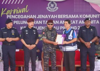AYOB Khan Mydin Pitchay (tengah) ketika menyerahkan sijil penghargaan kepada seorang penerima sempena Karnival Pencegahan Jenayah Bersama Komuniti & Majlis Peluncuran Taman Angkat Amanita Kontinjen Pulau Pinang di padang kawad USM, Pulau Pinang.-UTUSAN/DANIAL SAAD