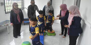 Mohamad Zaki Ismail (dua dari kiri) bersama guru-guru melihat anak-anak autisme melakukan aktiviti disediakan.