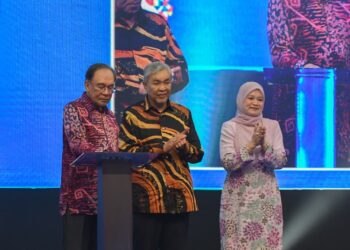 Fadhlina Sidek (kanan) mengiringi Anwar Ibrahim (kiri) melakukan gimik perasmian Sambutan Hari Guru Peringkat Kebangsaan kali ke-55 di Ipoh hari ini. - UTUSAN/ZULFACHRI ZULKIFLI.