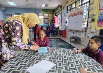 KU Aznita Ku Abdullah (kiri) menunjukkan teknik Kating kepada seorang murid prasekolah di Sekolah Kebangsaan (SK) Pusat Penyelidikan Pertanian Tun Razak di Jerantut, Pahang.