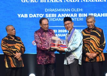 ANWAR Ibrahim menyampaikan Anugerah Tokoh Guru kepada Abdul Rashid Bakar pada pada Majlis Sambutan Hari Guru Peringkat Kebangsaan Kali Ke-55 di Perak