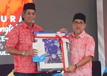 MD. Alwi Che Ahmad (kanan) menyerahkan cenderamata kepada Khairy Jamaluddin selepas merasmikan Majlis Kesyukuran Sempena Ulangtahun UMNO Ke-80 di Tapak Rumah UMNO Ketereh, Kota Bharu, Kelantan hari ini-UTUSAN/YATIMIN ABDULLAH.