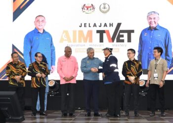Ahmad Zahid Hamidi (empat dari kiri) menyampaikan jaket dan topi kepada ikon AIM TVET sebagai simbolik pelancaran Kelab Kemahiran AIM TVET pada Jelajah  AIM TVET peringkat negeri Perak di Ipoh hari ini. - UTUSAN/ZULFACHRI ZULKIFLI.