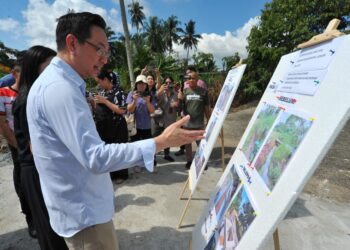 JIMMY PUAH Wee Tse melihat perkembangan sistem perparitan yang dalam pembinaan ketika meninjau kerja-kerja di Kampung Baru Ban Foo, Ulu Tiram, Johor Bahru disini. UTUSAN/RAJA JAAFAR ALI