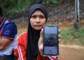 NUR Illyanis Suhaisham menunjukkan gambar abangnya ditemukan maut tertimbus ketika melombong emas di Jerimbong, Kuala Balah semasa di Unit Forensik Hospital Jeli, Kelantan-UTUSAN/KAMARUL BISMI KAMARUZAMAN.