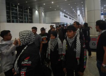OSMAN (memakai topi) ketika tiba di KLIA. - UTUSAN/FAISOL MUSTAFA