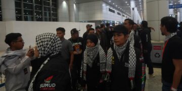 OSMAN (memakai topi) ketika tiba di KLIA. - UTUSAN/FAISOL MUSTAFA