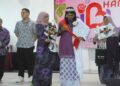 KALSOM Noordin memakaikan selendang kepada A. Parvathy yang dinobatkan penerima Anugerah Inspirasi Ibu sempena Majlis Sambutan Hari Ibu Peringkat Negeri di Dewan Komuniti Bukit Beruang, Melaka. - UTUSAN/AMRAN MULUP