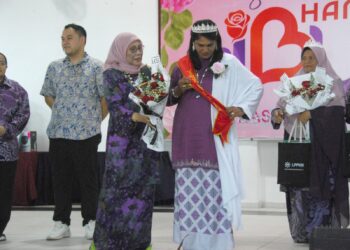 KALSOM Noordin memakaikan selendang kepada A. Parvathy yang dinobatkan penerima Anugerah Inspirasi Ibu sempena Majlis Sambutan Hari Ibu Peringkat Negeri di Dewan Komuniti Bukit Beruang, Melaka. - UTUSAN/AMRAN MULUP