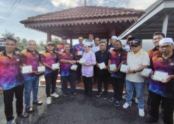 AHMAD Maslan (tengah) menyampaikan daging korban kepada ketua ketua kampung mukim Benut di Kompleks Penghulu Mukim Benut, Pontian.