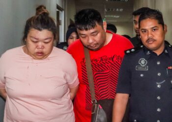 TAN Kok Teong (tengah) dan Koon Pheng (kiri) diiringi anggota polis bagi dihadapkan ke Mahkamah Sesyen Butterworth, Pulau Pinang semalam atas pertuduhan memperdagangkan wanita warga Indonesia bagi tujuan buruh paksa. – UTUSAN/DANIAL SAAD