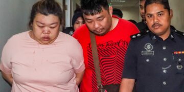 TAN Kok Teong (tengah) dan Koon Pheng (kiri) diiringi anggota polis bagi dihadapkan ke Mahkamah Sesyen Butterworth, Pulau Pinang semalam atas pertuduhan memperdagangkan wanita warga Indonesia bagi tujuan buruh paksa. – UTUSAN/DANIAL SAAD