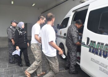DUA tertuduh (tiga dari kiri) dibawa keluar dari Kompleks Mahkamah Kangar, Perlis, hari ini.-UTUSAN/ASYRAF MUHAMMAD