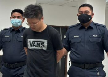 TERTUDUH semasa dibawa polis untuk menghadiri prosiding perbicaraan di Mahkamah Majistret Kota Bharu, Kelantan.