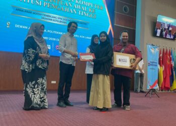 MUHAMMAD Kamil Abdul Munim (dua dari kiri) menyampaikan sumbangan kepada pelajar cemerlang pada Program Sumbangan Komputer Riba dan Bantuan Awal ke Institusi Pengajian Tinggi di Politeknik Kota Bharu,Kelantan. - UTUSAN/ROSMIZAN RESDI