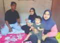 HASLINA Othman (kanan) bersama anaknya, Nor Azimah Che Kassim yang memangku cucu berusia 36 hari ketika berlindung di PPS Dewan Keda Sungai Tengas, Bandar Baharu. Kedah semalam.