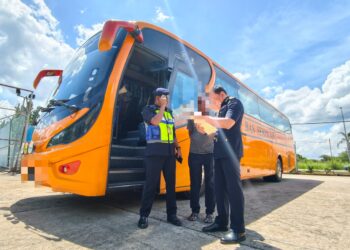 STIEN Van Lutam (kanan) memeriksa dokumen sebuah bas yang disyaki menyalahgunakan permit bas sekolah di Stesen Penguat Kuasa JPJ Kuala Ketil, Baling hari ini.