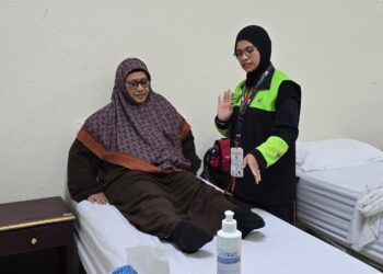 AZLINDA Abdul Hamid ketika sesi fisioterapi bersama salah seorang jemaah haji.