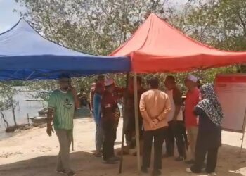 AHLI keluarga dan penduduk menunggu perkembangan operasi mencari dan menyelamat dua remaja yang hilang dibawa arus deras ketika beriadah di Sungai Paka, Dungun, Terengganu.