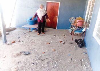 PENDUDUK menunjukkan pasir yang memenuhi rumah mereka akibat kejadian air pasang besar di Kampung Huma, Tanjung Dawai di Sungai Petani.