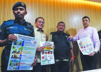 H'NG Mooi Lye (kanan) menunjukkan kamera badan dipakai seorang penguat kuasa PBT di George Town, Pulau Pinang.-UTUSAN/DANIAL SAAD