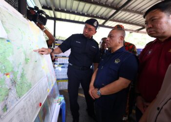 SAARANI Mohamad (tengah) mendengar taklimat operasi daripada Timbalan Ketua Polis Daerah Tapah, Deputi Superintenden Mohd. Fadzil Ismail (kiri) ketika meninjau PKTK SAR Gunung Batu Putih di Surau At-Taqwa, Stesen Janakuasa Sultan Idris II, Kuala Woh di Tapah hari ini.