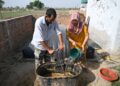 PENDUDUK menuangkan najis lembu ke dalam loji biogas mereka di sebuah kampung di daerah Bulandshahr, Uttar Pradesh.-AFP