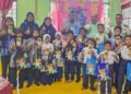 ROSDI Mat Diah (belakang, tiga dari kanan) bersama guru dan murid beragama Islam yang menerima sumbangan sempena hari raya di Sekolah Kebangsaan Sungai Kiol, Jerantut, Pahang baru-baru ini