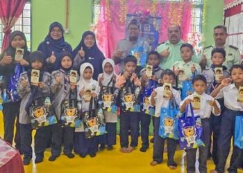 ROSDI Mat Diah (belakang, tiga dari kanan) bersama guru dan murid beragama Islam yang menerima sumbangan sempena hari raya di Sekolah Kebangsaan Sungai Kiol, Jerantut, Pahang baru-baru ini
