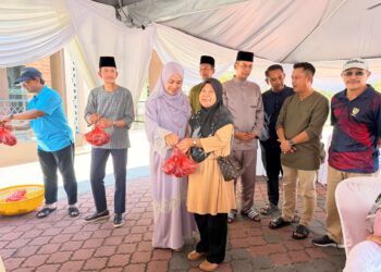 Cik Puan Anis Sobari ditemani Tunku Syed Razman menyampaikan sumbangan daging korban kepada penerima di Majlis Ibadah Korban sempena Aidiladha, di perkarangan Surau Al- Khusyu', Balai Kediaman Rasmi Tunku Besar Tampin, hari ini.