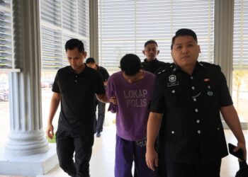 TERTUDUH (tengah) semasa dibawa polis menghadiri prosiding perbicaraan di Mahkamah Sesyen Pasir Mas, Kelantan. - UTUSAN/KAMARUL BISMI KAMARUZAMAN